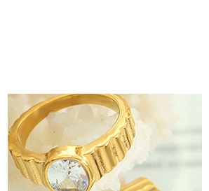 Macro d'une bague dorée ornée d'une grande pierre précieuse claire et d'un anneau texturé