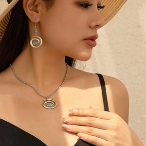 Detail of vintage bohemian silver necklace and spiral earrings set with turquoise