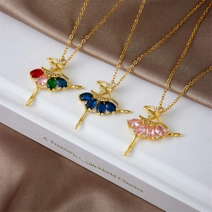 Golden ballet dancer pendant necklace with multi-colored crystals on a classic background