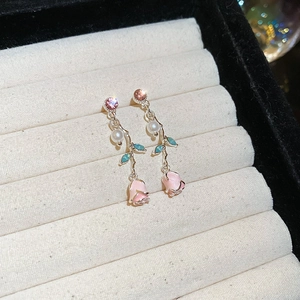 Macro shot of silver flower drop earrings with pink enamel rose petals and pearls