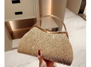 Detail of glitter gold evening clutch bag with round metal handle and diamond clasp