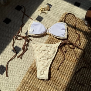 Two-piece backless bikini with cream mesh fabric, brown ties and V-shaped gold metal hardware