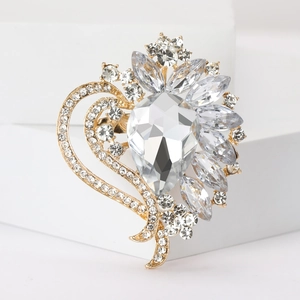 Macro detail of gold-toned crystal brooch featuring pear and marquise-cut stones