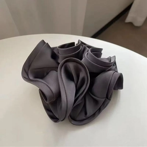 Close-up of dark grey silk satin scrunchie showing smooth texture and ruffled details