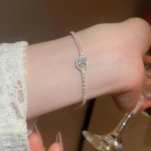 Close-up of elegant gold bracelet with oval zircon stones on a model's wrist