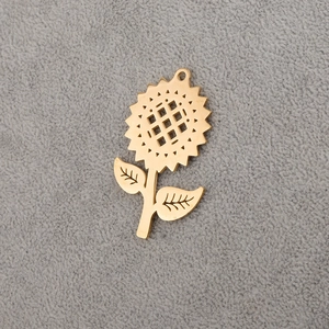 Detailed macro view of golden stainless steel sunflower pendant with hanging loop on gray felt