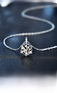 Macro close-up of a classic six-prong moissanite pendant on a 925 silver chain