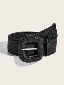 Détail d'une ceinture tressée noire avec boucle ronde et bout en cuir sur fond beige