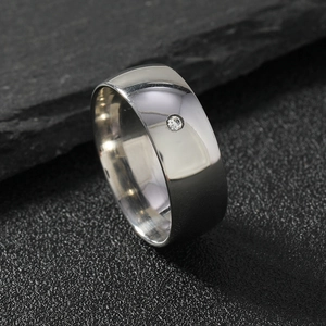 Titanium steel ring with single round gemstone on black slate background