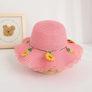 Dettaglio cappello di paglia rosa per bambini con bordo in pizzo e girasoli carini