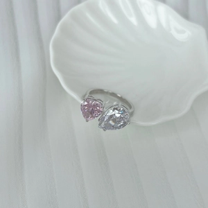 Détail de gemmes rose cœur et poire sur une bague argentée dans un plateau coquille