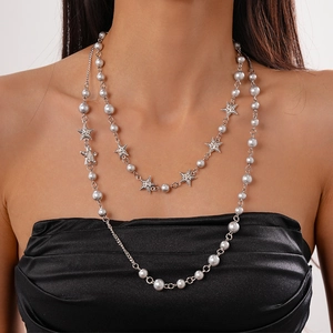 Detail of layered silver star and grey faux pearl long necklace on a model