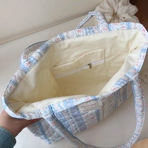Detail of floral quilted tote bag interior with zipper pocket and spacious capacity