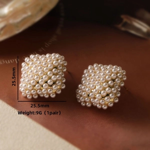 Macro shot of square pearl stud earrings with gold base showing 25.5mm size detail