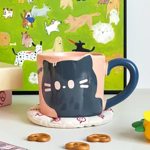 Close-up of pink ceramic cat mug with blue handle and Lucky Kitten lettering