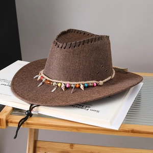 Detail of dark brown cowboy straw hat with colorful beads, shells and feather pendant