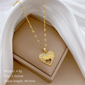 Close-up of golden heart MAMA pendant with diamonds, elegantly set on silk fabric