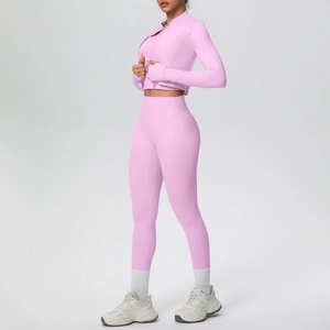 Detailed close-up of pink yoga set featuring thumbhole cuffs and high-waist sports leggings