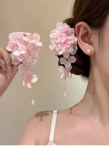 Detailed view of pink floral hair clips with golden tassels and teardrop pearl charms