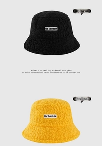 Detail of lamb wool bucket hat featuring textured faux fur and rectangular letter patch