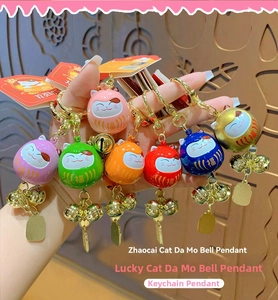 Detailed view of colorful Maneki Neko bell keychains with lucky charms and golden clasps