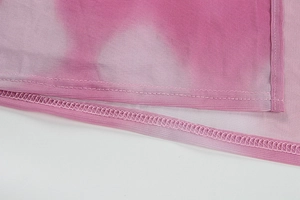Macro detail of pink purple tie-dye mesh fabric showing neat stitching and fine texture