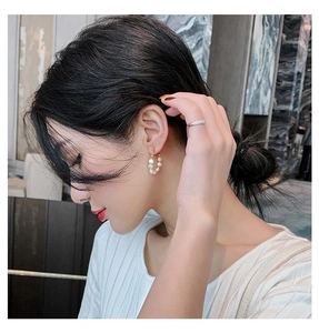 Modelo luciendo pendientes de aro dorados con perlas naturales de agua dulce de lujo