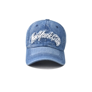 Detailed view of New York City 3D embroidery on washed denim baseball cap with frayed edges
