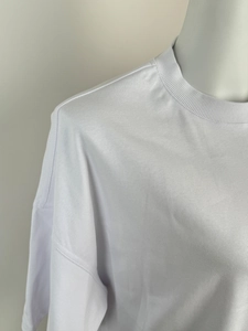 Close-up of white crew neck T-shirt showing high-quality stitching and drop shoulder seams