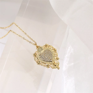 Vue macro du collier cœur doré avec zircons micro-pavés et filigrane baroque
