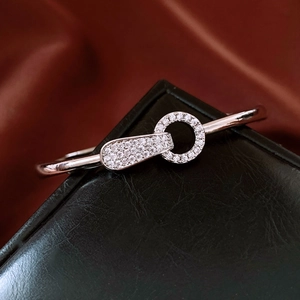 Gros plan du bracelet jonc argenté avec fermoir serti de zircons sur cuir noir
