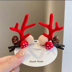 Detail of Christmas reindeer antler hair clips with pine cones and mushrooms on card