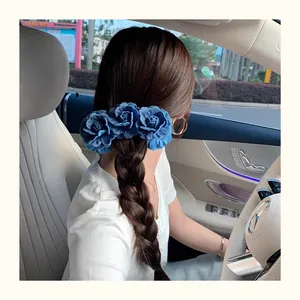 Detail of vintage denim blue floral hair clip worn on braided hair in a car setting