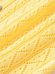 Vue macro d'un tricot ajouré jaune vif avec motif en losange et texture de maille douce
