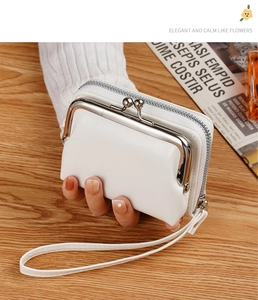 Detail view of a white vintage PU leather coin purse with metal kiss lock and wrist strap