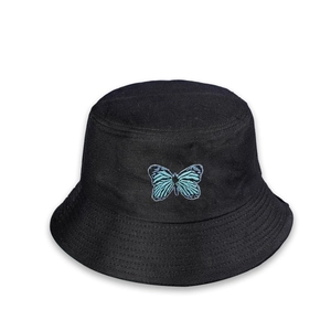 Détail de la broderie délicate de papillon bleu sur un chapeau bob en coton noir
