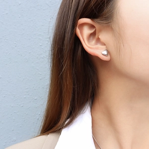 Minimalist silver heart stud earrings for women shown on model for stylish look