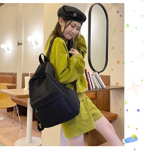 Lifestyle shot of a stylish large black backpack being worn in a cozy cafe setting