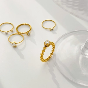 Detail of 18K gold plated titanium steel rings with various cubic zirconia settings