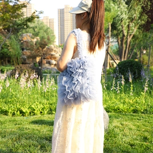 Blue ruffled lace tote bag with tiered mesh design shown in a scenic outdoor setting