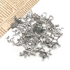 Detailed macro shot of vintage silver angel and cupid charms on a white background