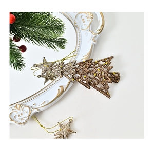 Close-up of glittering gold Christmas tree and star ornaments on an elegant tray