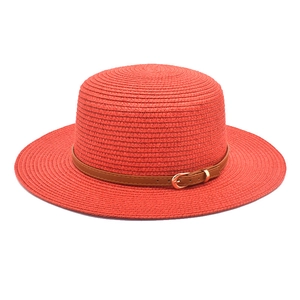 Red woven straw boater hat with a brown faux leather belt buckle and wide brim for summer
