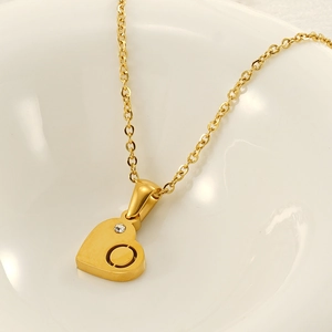 Dettaglio della collana a cuore dorata con zircone lucido e raffinato design traforato
