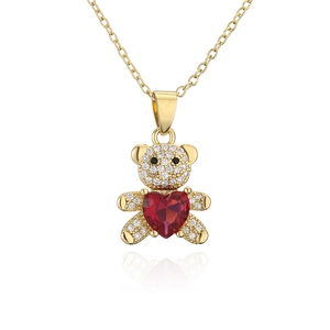Vue détaillée d'un pendentif ours en peluche doré avec zircons et pierre en cœur rouge