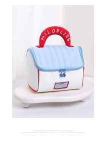Dettaglio della borsa trapuntata con manico rosso e ricamo bianco elegante