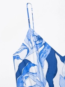 Close-up of thin shoulder straps and blue floral print on a summer midi dress