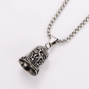 Detail of St. Michael silver bell pendant with embossed feather wings and protect us text