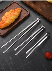 Close-up of three 304 stainless steel food tongs with non-slip serrated tips on marble