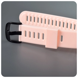 Close-up of pink breathable silicone watch strap with multiple holes and black metal buckle